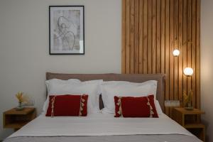 a bedroom with a bed with red and white pillows at VICANTI Luxury Apartments in Pylos