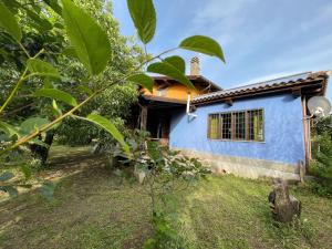 uma casa com uma parede azul e uma árvore em Country House tra lago e mare a Sud di Roma em Campoleone