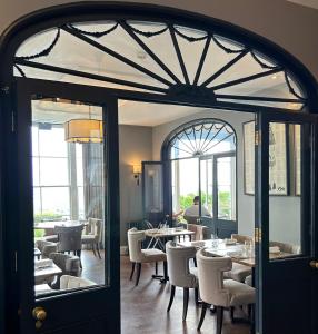 a dining room with tables and chairs and a window at Cottage In The Wood in Great Malvern