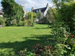 a garden with a large lawn with houses at Aberlour Cottages - Bolthole & Retreat in Aberlour