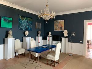uma sala de jantar com uma mesa e cadeiras e um lustre em Palazzo Carratelli em Amantea