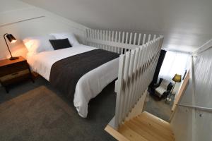 a bedroom with a white bed with a black blanket at Destination Owl's Head - Mtn Haus in Mansonville