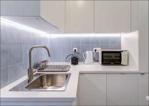 uma cozinha com um lavatório e um micro-ondas em Zaire Retreat Apartment em Lisboa