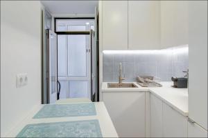 uma cozinha com armários brancos e um lavatório em Zaire Retreat Apartment em Lisboa