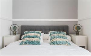 sypialnia z białym łóżkiem z niebieskimi poduszkami w obiekcie Zaire Retreat Apartment w Lizbonie