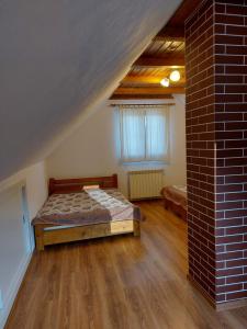una camera con letto e muro di mattoni di Tulipános Vendégház 