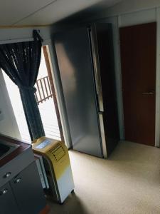 ein leeres Zimmer mit einem Kühlschrank und einem Fenster in der Unterkunft Mobil-home sur terrain privé in Sérignan