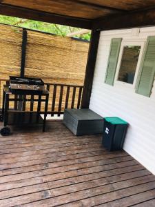 a screened in porch with a grill and a trash can at Mobil-home sur terrain privé in Sérignan