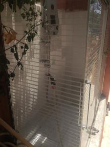 una ducha en una habitación con persianas en una ventana en Romantic Woodhouse casita camping, en Aguatona