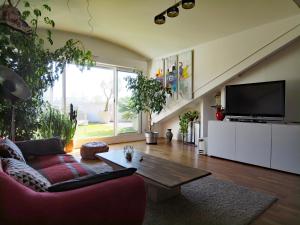 uma sala de estar com um sofá vermelho e uma televisão em L'OASIS - Loft standing - Terrasse Rooftop - Jacuzzi Spa - Parking em Baiona