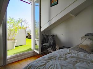 um quarto com uma cama e uma grande janela em L'OASIS - Loft standing - Terrasse Rooftop - Jacuzzi Spa - Parking em Baiona