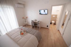 Cette chambre blanche comprend un lit et une table. dans l'établissement GREEN - Bed and Breakfast a Castrovillari, à Castrovillari