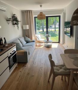 a living room with a couch and a table at Albatross Beach Apartment - SPA, Sea and Forest in Ķesterciems