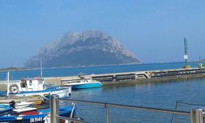 a mountain in the distance with boats in the water at Affittacamere D&D in Porto San Paolo