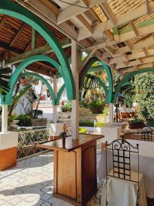 une terrasse avec des arches vertes, une table et des chaises dans l'établissement La Résidence d'Ankerana, à Antananarivo