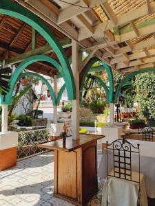 an outdoor patio with green arches and a table and chairs at La Résidence d'Ankerana in Antananarivo