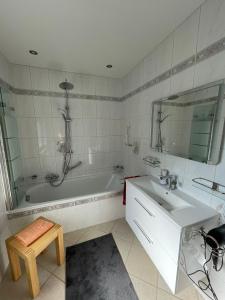 La salle de bains blanche est pourvue d'une baignoire et d'un lavabo. dans l'établissement Ferienwohnung Moncho, à Hagenburg