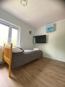 a bedroom with a bed and a flat screen tv at Dolores in Giżycko