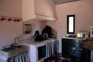 een keuken met een fornuis, een wastafel en een aanrecht bij Casa do Caseiro in Sobrena
