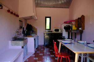 una cucina con sedie rosse e tavoli in una stanza di Casa do Caseiro a Sobrena