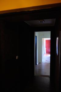 Camera oscura con corridoio che conduce a una stanza con tavolo di Casa do Caseiro a Sobrena