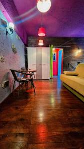 een kamer met een tafel en een bed en paarse plafonds bij Hostel Bermuda in Lesce