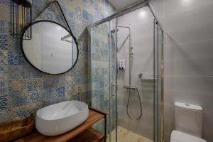 La salle de bains est pourvue d'un miroir, d'un lavabo et d'une douche. dans l'établissement VICANTI Luxury Apartments, à Pylos