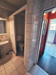 a bathroom with a toilet and a sink at Hostel Bermuda in Lesce