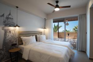 a bedroom with two beds and a balcony at Prasonisi Light House Boutique Hotel in Prasonisi