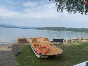 una piccola barca seduta sull'erba vicino all'acqua di casa in riva al lago Diletta Spiti a Castelletto sopra Ticino