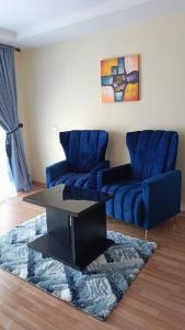 uma sala de estar com duas cadeiras azuis e uma mesa em Oceanfront Wavecrest Hotel em Lekki