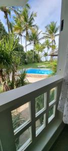a view from the balcony of a resort with a swimming pool at Vista para o mar Arraial d'Ajuda in Arraial d'Ajuda