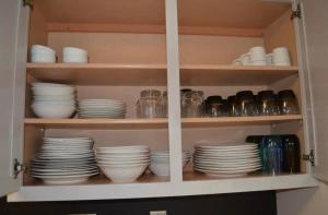 Un armario lleno de platos, tazas y vajilla. en The Redhawk Hideaway: Charming 2BR Condo near Miami Univ in Oxford! Book now!, en Oxford 5 fotos más