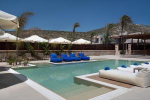 a pool with blue and white chairs and umbrellas at Prasonisi Light House Boutique Hotel in Prasonisi
