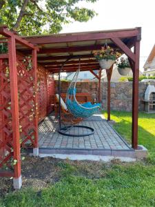 a hammock on a patio under a pergola at Dom wypoczynkowy FENIX in Werblinia