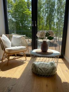 um quarto com uma mesa, uma cadeira e um vaso em Albatross Beach Apartment - SPA, Sea and Forest em Ķesterciems