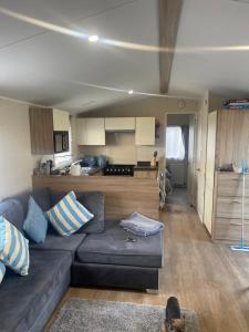 a living room with a couch and a kitchen at The Hideaway Cabin in Seasalter