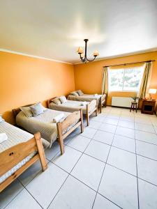 um quarto com três camas e uma janela em Hotel El Almendro em Paine