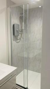 a shower with a glass door in a bathroom at Luxury beach front rooms- PMA in Kirkcaldy