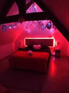 ein Schlafzimmer mit rosa Lichtern und ein Bett in einem Zimmer in der Unterkunft la caliente in Saint-Mars-sur-la-Futaie