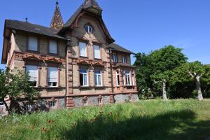 ein altes Haus auf einem Grashügel in der Unterkunft Ferienwohnung Camino in Jockgrim