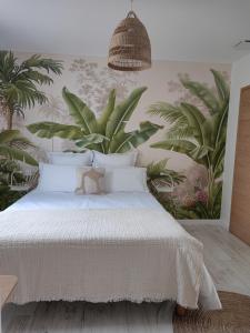 una camera da letto con un letto bianco e piante sul muro di La Parenthèse Cormillonne a Corme-Écluse