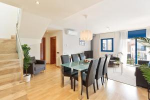 comedor y sala de estar con mesa y sillas en Lucas House Apartments by Sitges Group, en Sitges