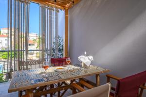 a table with two glasses of wine on a balcony at VICANTI Luxury Apartments in Pylos +28 photos