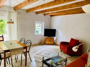 a living room with a red couch and a table at Ferienwohnung mit schöner Terrasse. in Ellerstadt