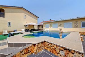 una piscina con una estatua frente a una casa en Zen Village Rosa, en Fernao Ferro