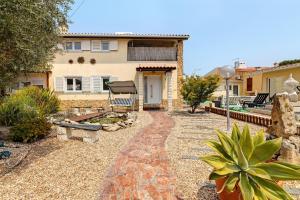 ein Haus mit einem Steinweg, der zu einem Hof führt in der Unterkunft Zen Village Rosa in Fernão Ferro