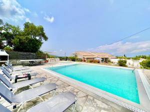 uma piscina com espreguiçadeiras ao lado de uma piscina em Villa Kessar St Stephanos with private pool em Ágios Stéfanos