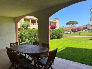 サリ・ソランザラにあるPALMERAIE 412- piscine en résidence-clim-wifiのパティオ(テーブル、椅子付)、緑豊かな庭園