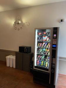 uma máquina de venda automática de refrigerantes com bebidas num quarto em Cit'Hôtel le Welcome em Moutiers